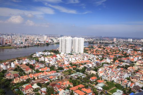 Free Aerial view of Ho Chi Minh City's urban landscape along a river, showcasing high-rise buildings and vibrant neighborhoods. Stock Photo