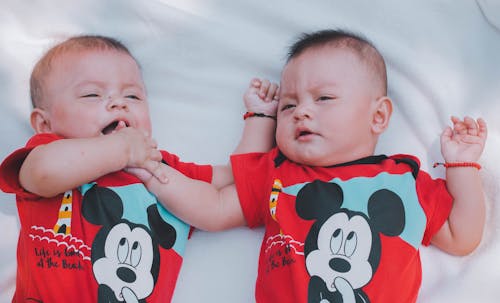 赤いミッキーマウスのシャツを着た2人の赤ちゃん