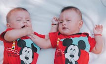 Two Babies Wearing Red Mickey Mouse Shirts