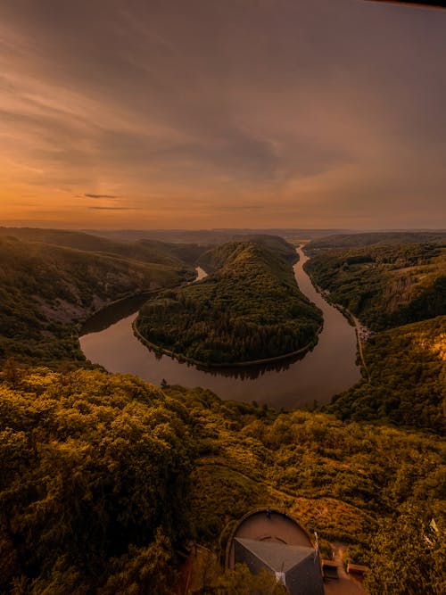 The sun sets over a river and hills