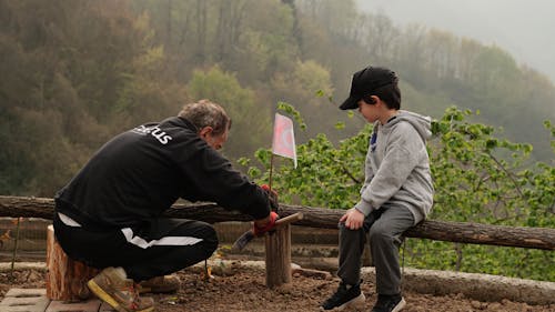 Man with Boy Leaving Flag in Foggy Autumn Countryside