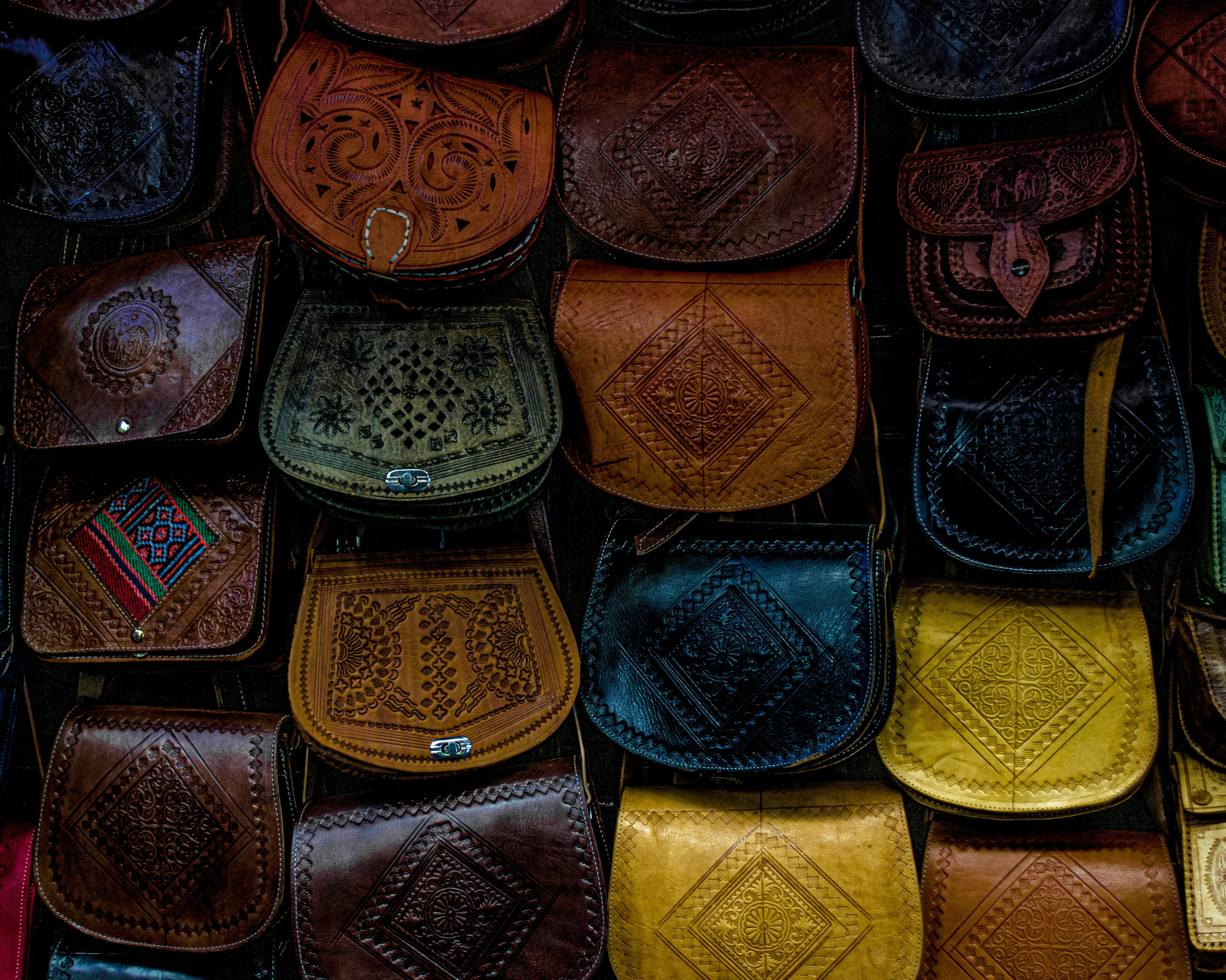 A vibrant collection of handcrafted Moroccan leather bags, showcasing unique patterns and designs.