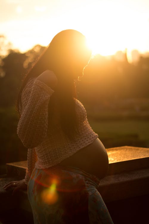 A pregnant woman standing in the sun