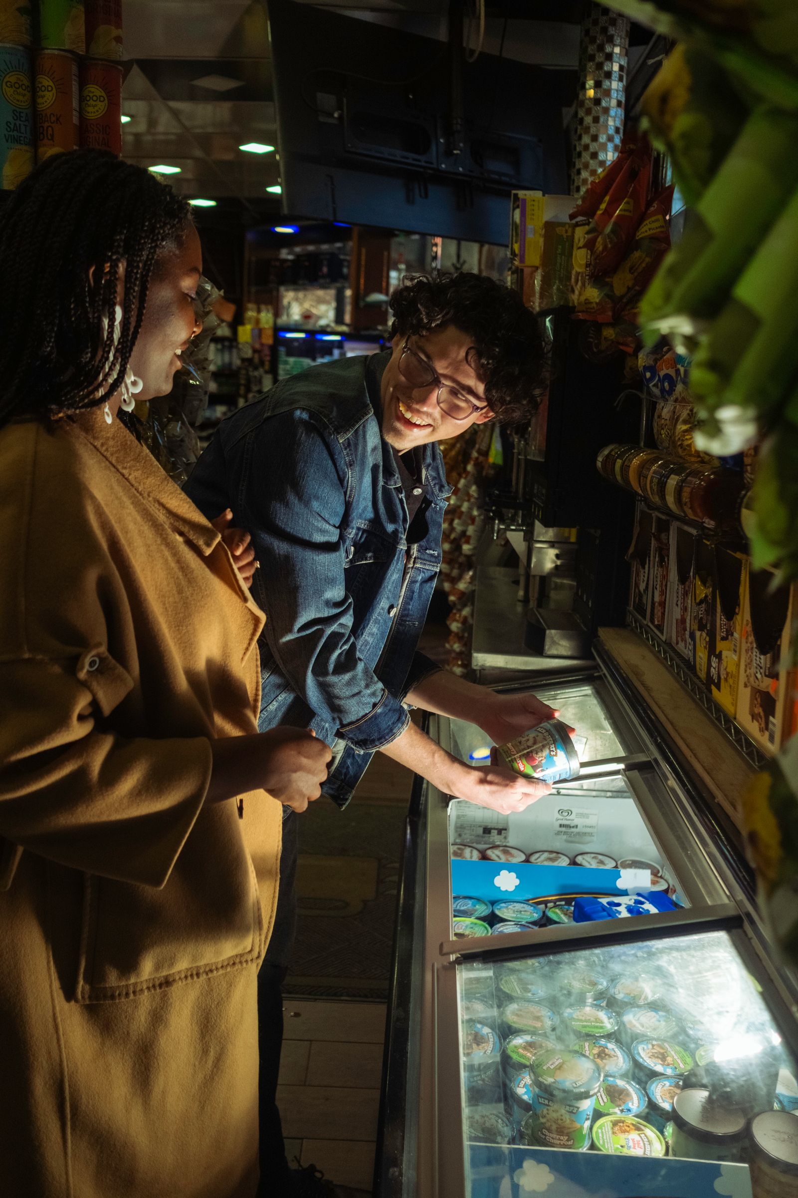 Shoppers selecting packaged ice cream from a freezer