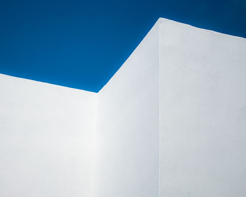 A striking minimalist image of a geometric white wall set against a clear blue sky in Rabat, Morocco.