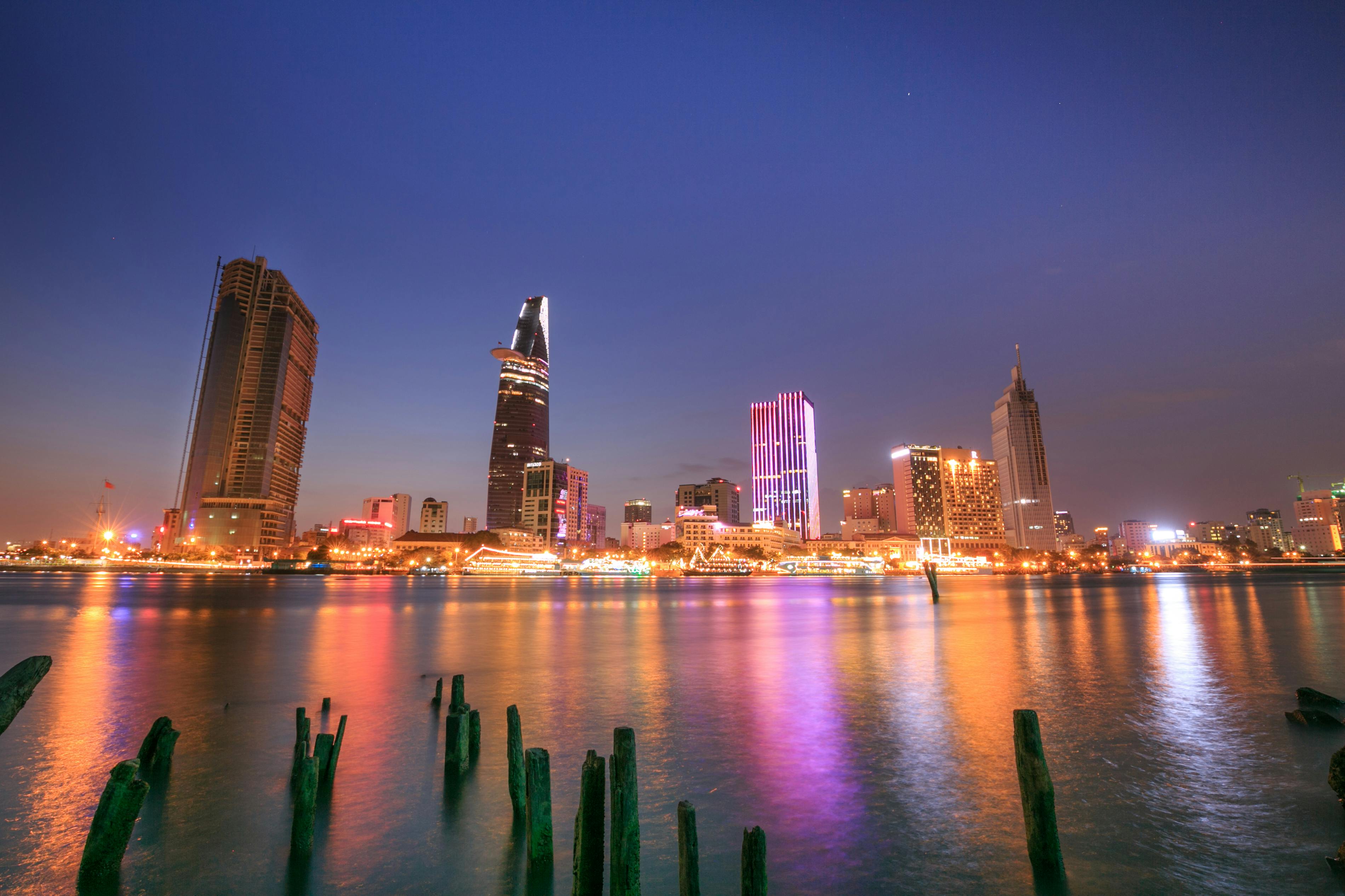 黄昏时分，胡志明市美丽的天际线被点亮，倒映在河面上