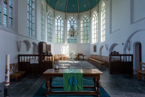 The interior of a church with a large window and a green table