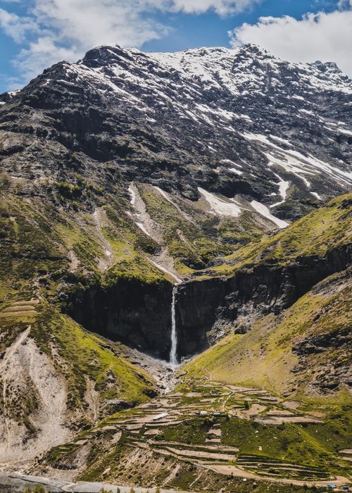 Free A stunning waterfall cascades down the lush green Himalayan mountains, showcasing nature's beauty. Stock Photo