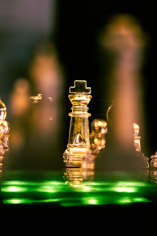 Free A striking image of crystal chess pieces illuminated by dramatic lighting, highlighting the queen. Stock Photo