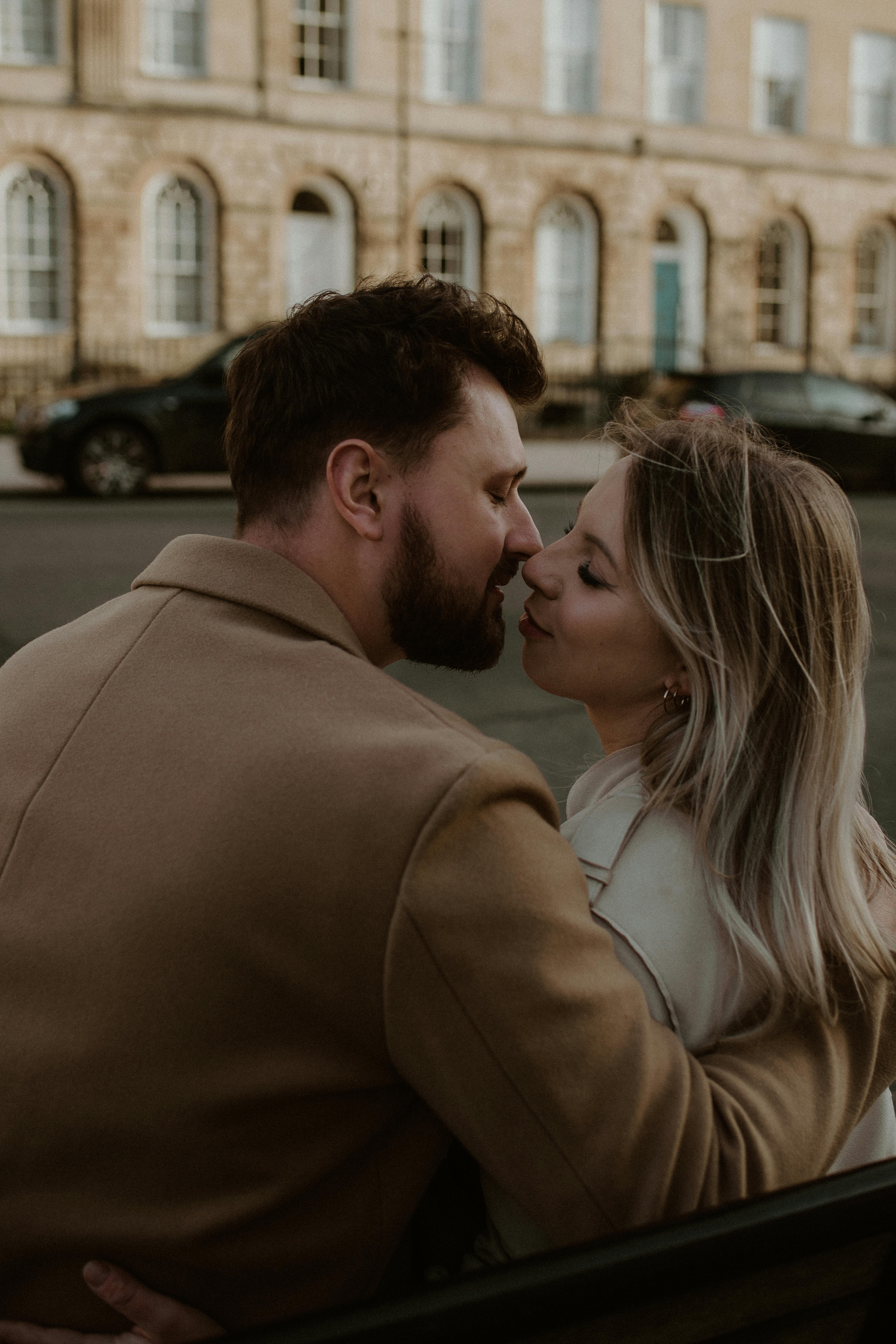 A couple lovingly embracing on a street in Bath, England, showcasing romance and connection.