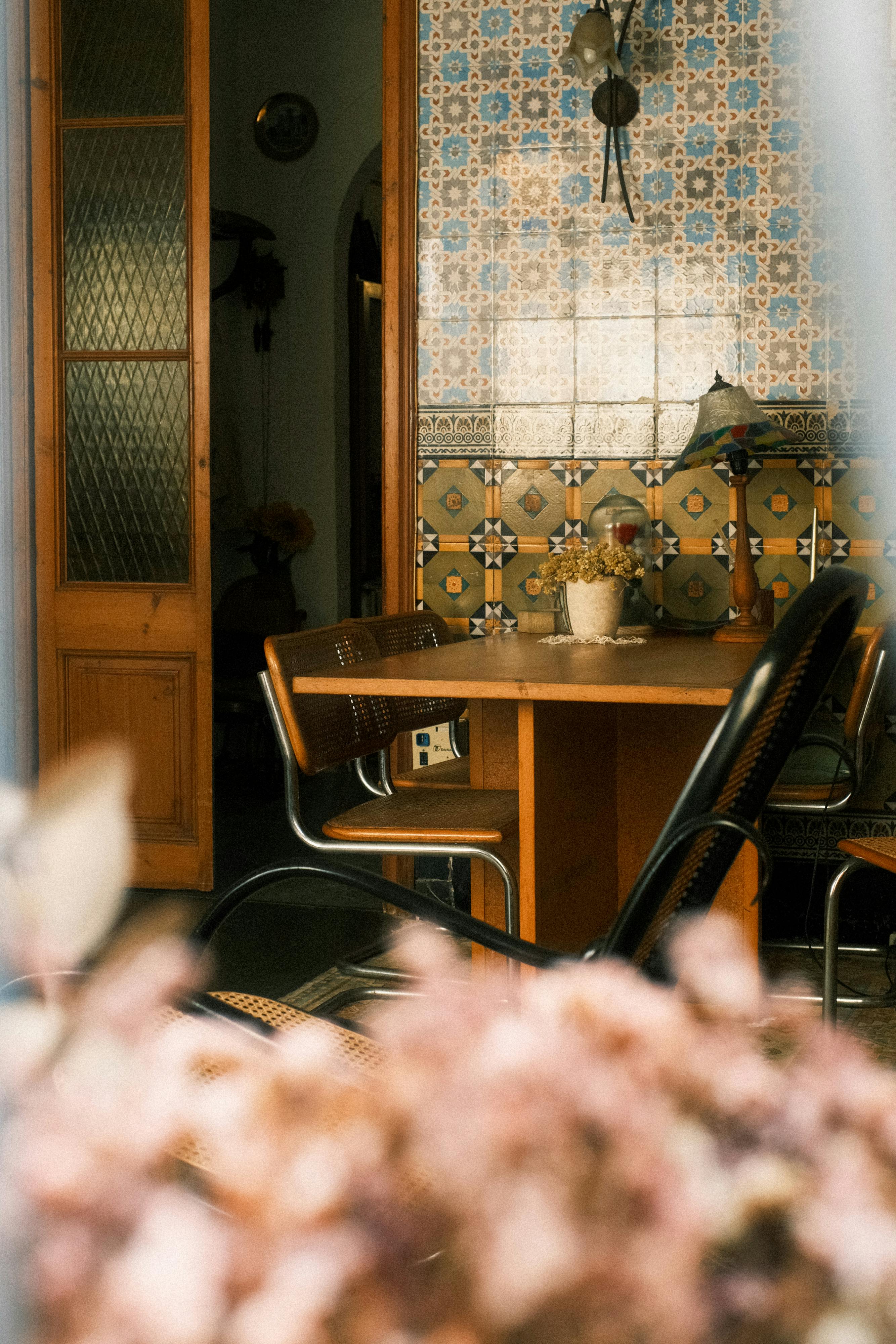 Warm Mediterranean-style room with vintage tiles, wooden table, and chairs.
