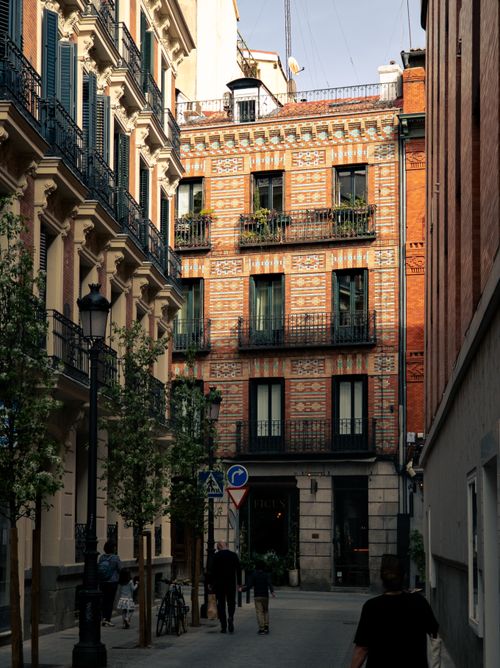 Free A picturesque alley in Madrid showcasing vibrant historic architecture under sunny skies. Stock Photo
