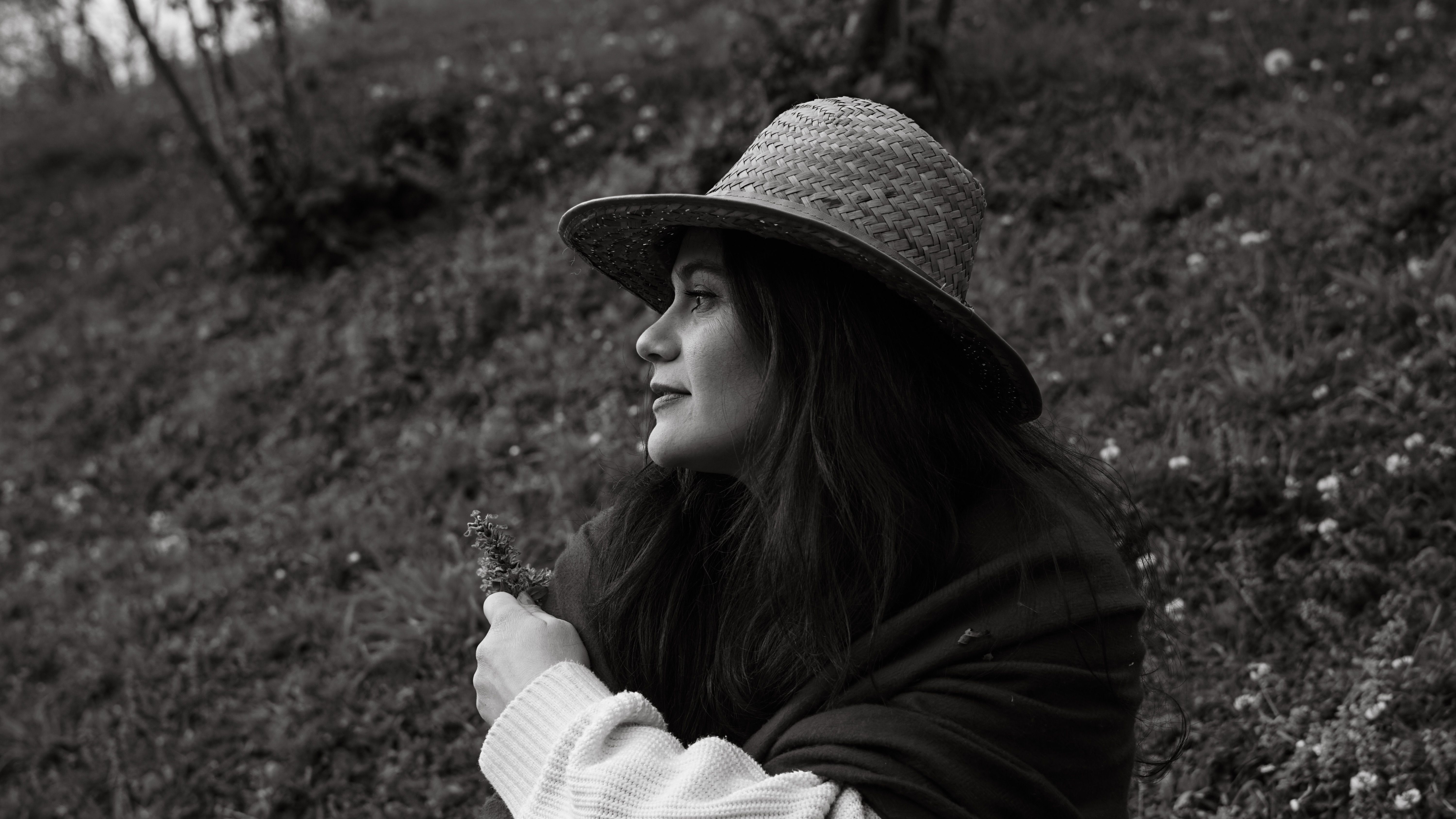Woman Sitting on a Field and Holding a Flower · Free Stock Photo