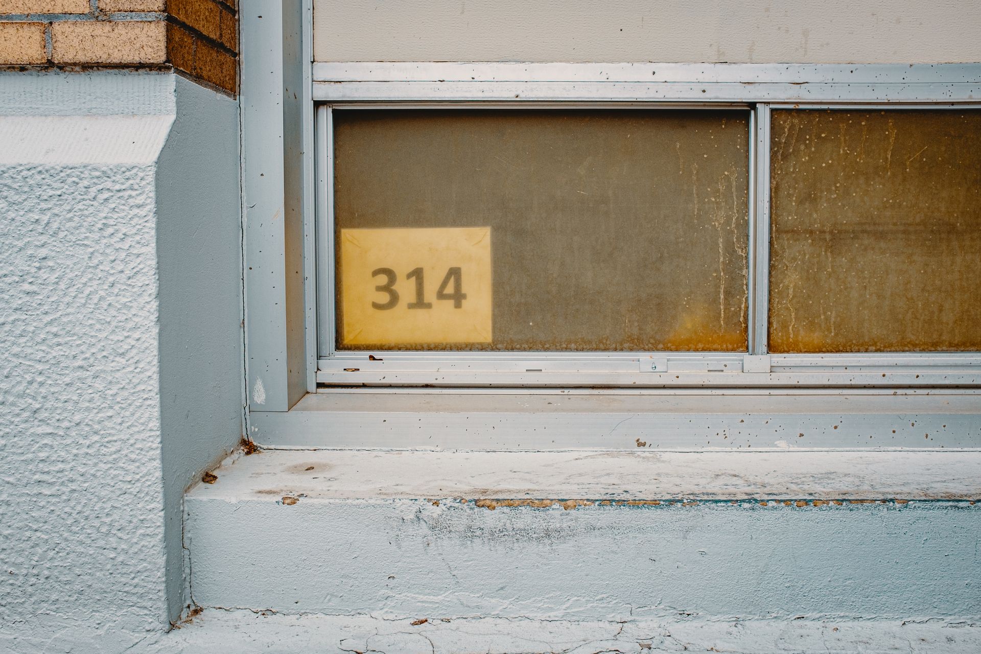 Weathered urban window with number 314 in Boise, Idaho.