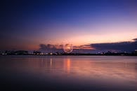 日落时分，宁静的水面上倒映着一个迷人的摩天轮