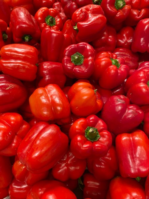 Free Close-up of fresh red bell peppers on display, showcasing their vibrant color and healthy appeal. Stock Photo