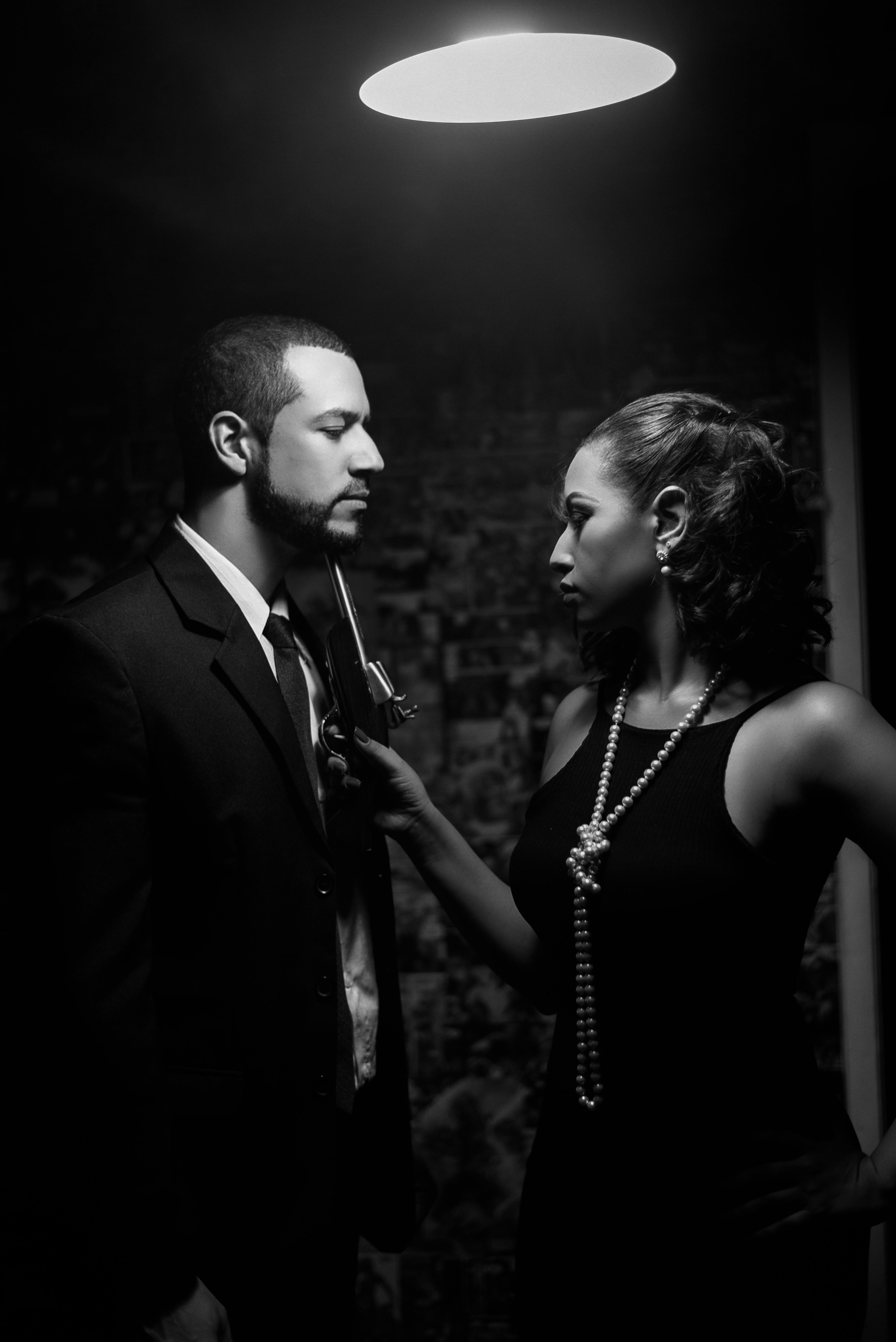 Elegant couple in noir setting evoking 1940s mystery and style.