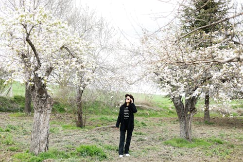 A woman standing in front of some trees