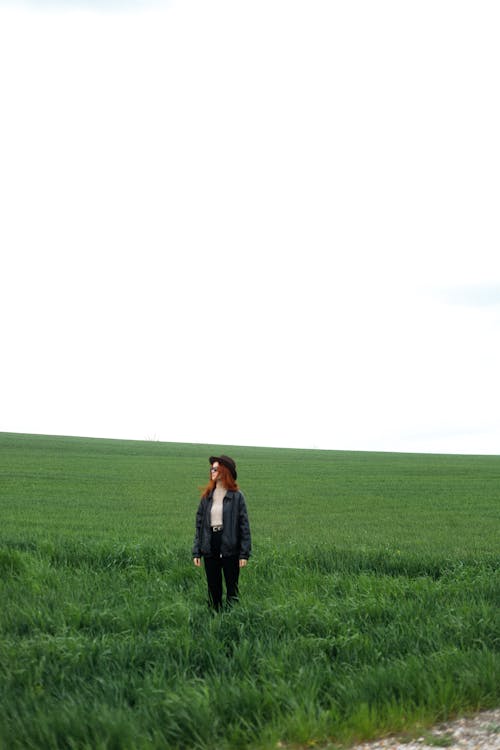 A woman standing in a field of green grass