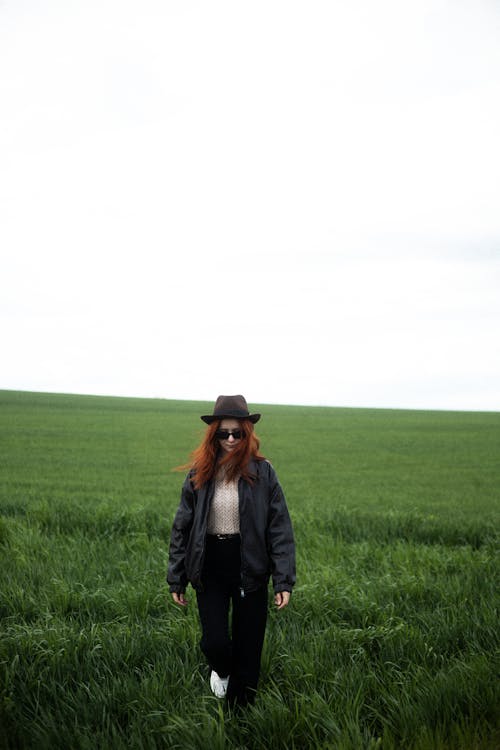 Redhead Woman in Hat on Grassland