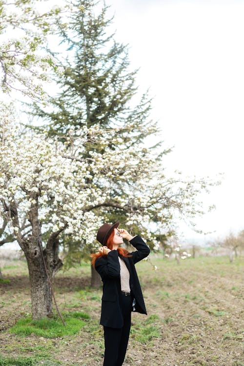 A woman standing in front of a tree with blossoms