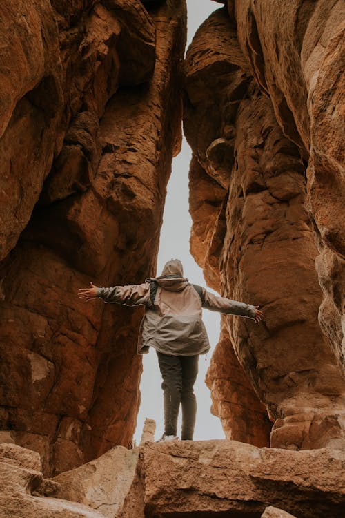 A person standing in the middle of a canyon