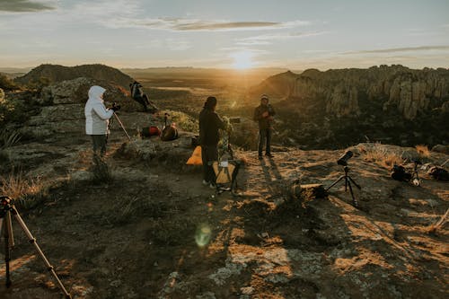 Three people standing on a rock with a camera