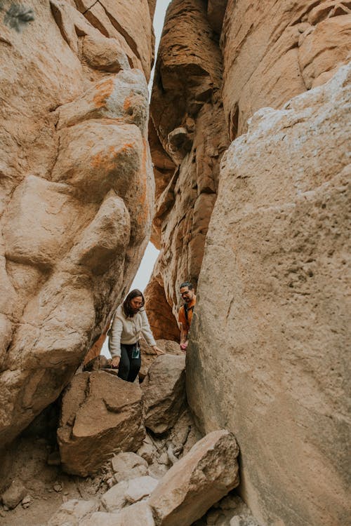 Two people walking through a narrow canyon