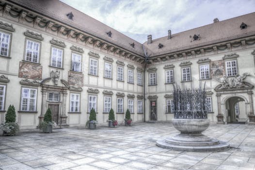 An elegant historical European courtyard showcasing architectural details and decorative elements.