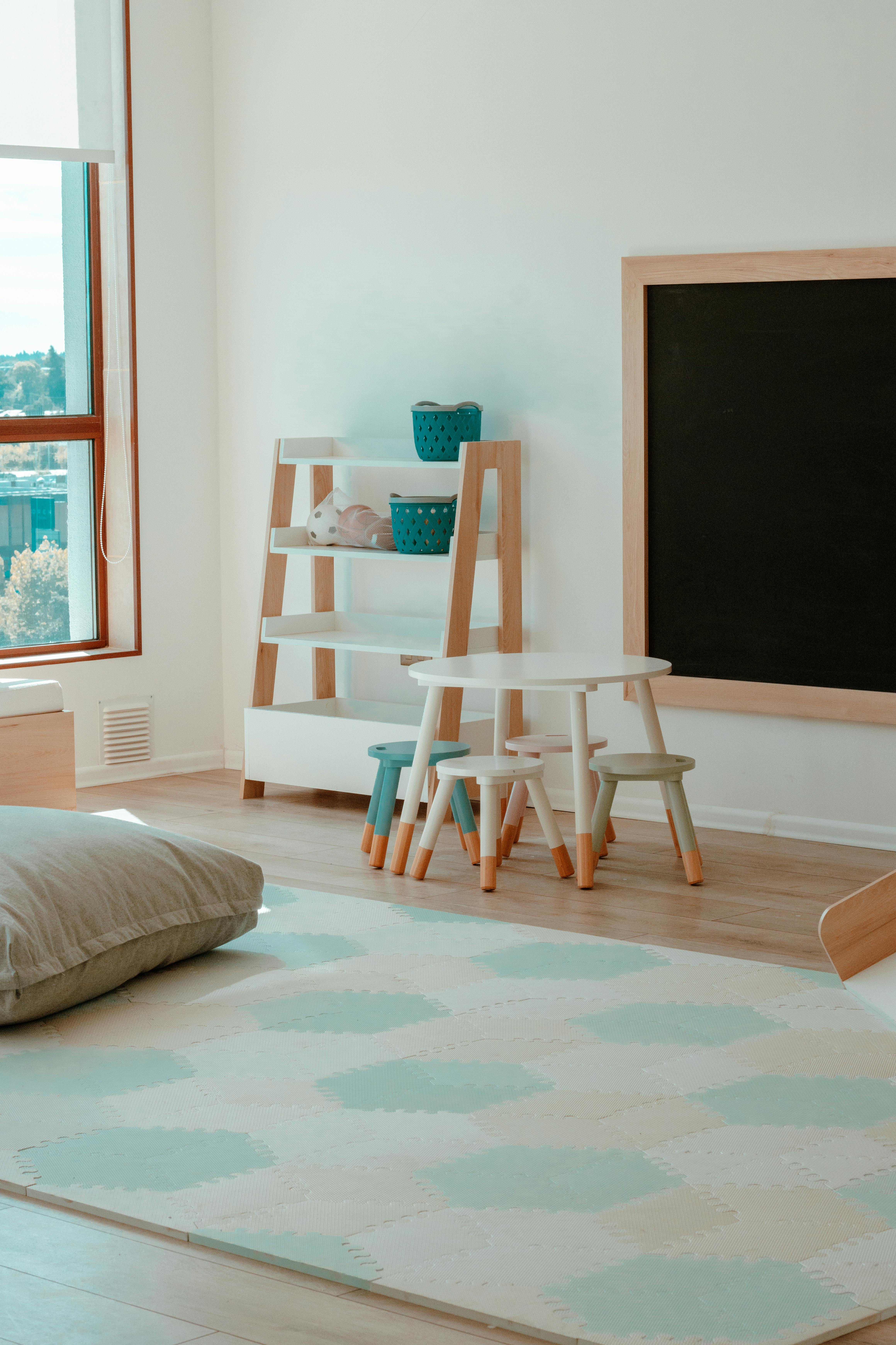 Stylish children's playroom with minimalist decor, chalkboard, and natural light.