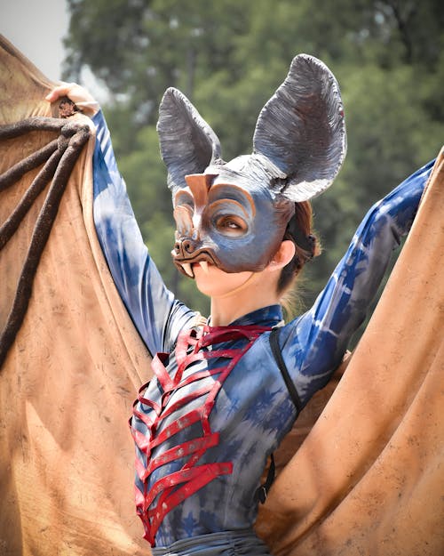 A woman in a bat costume holding a bat