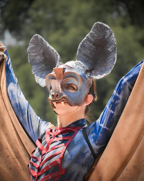 A woman in a costume with a bat mask