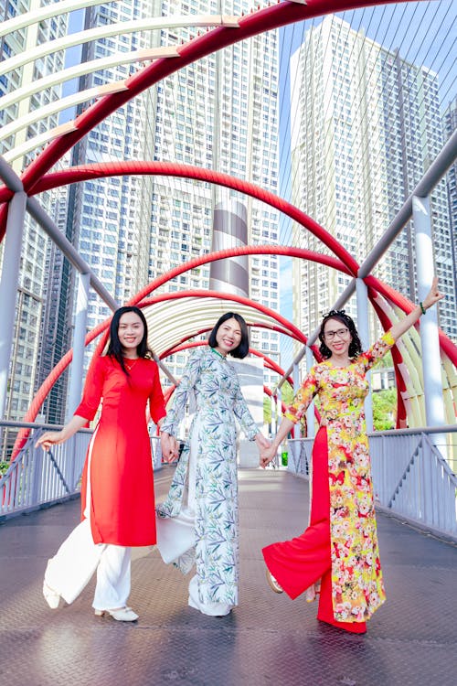 Free A Group of Women in Traditional Clothing Standing on the Pedestrian Bridge in Ho Chi Minh City, Vietnam  Stock Photo