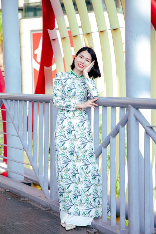 Free A woman in a long dress posing on a bridge Stock Photo