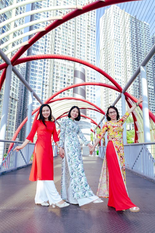 Free Three women in traditional chinese clothing pose on a bridge Stock Photo