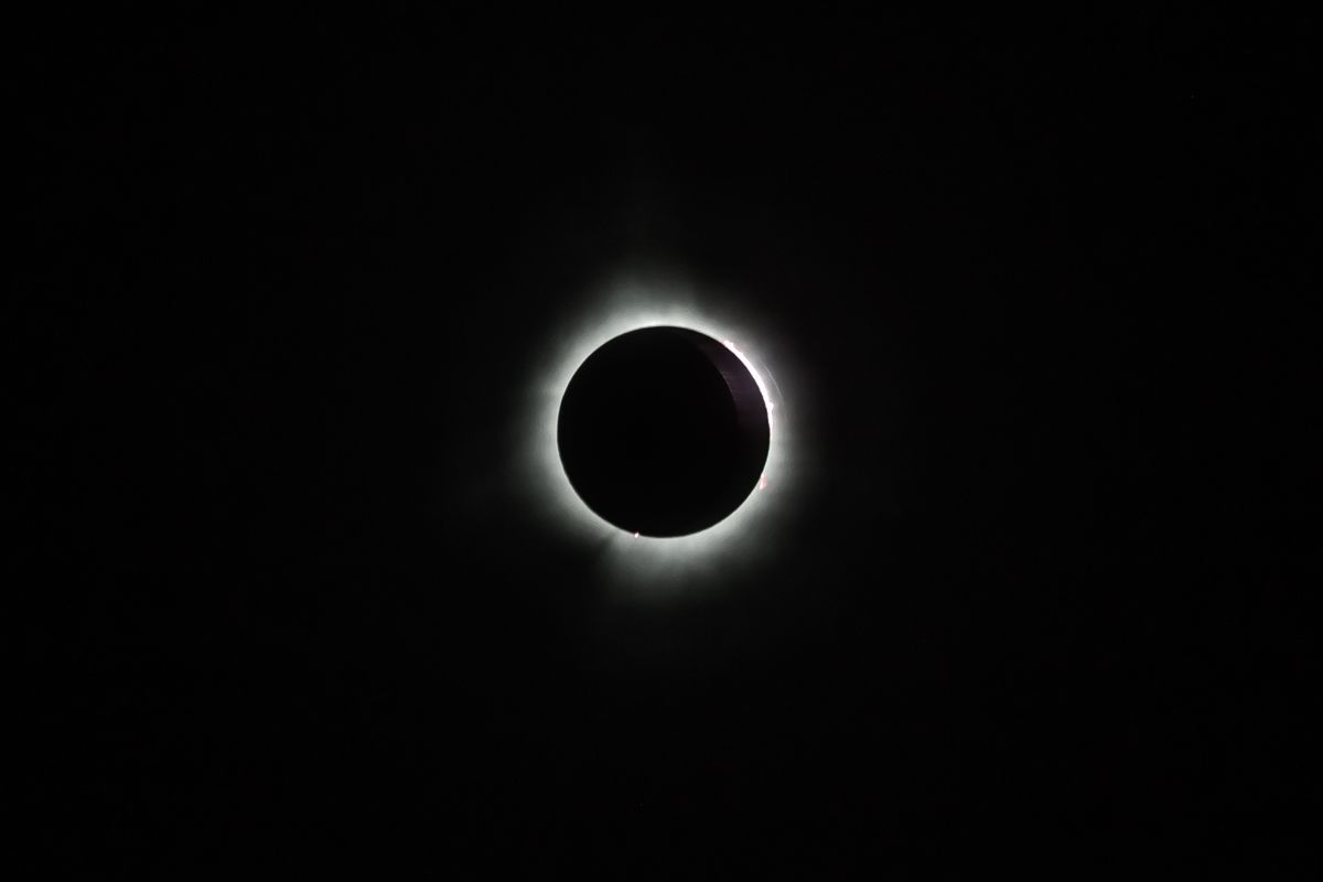 Glowing halo of a total solar eclipse in a dark night sky