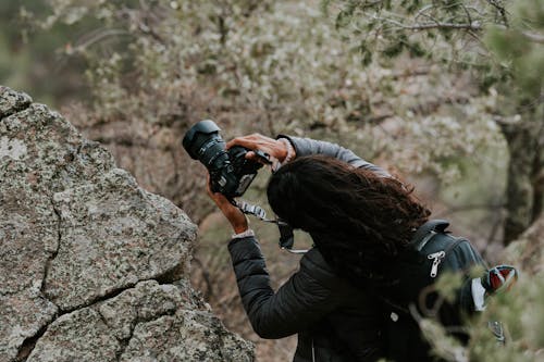 Photographer Holding Camera Among Rocks 