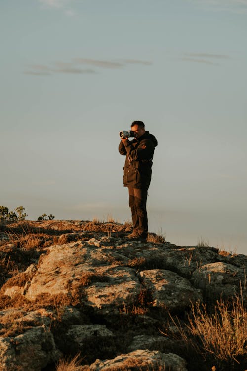 A man taking a photo on a rock