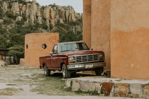 A red truck parked in front of a stone building