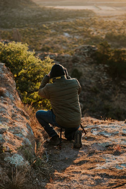 Man Taking Pictures in a Valley During Sunset 