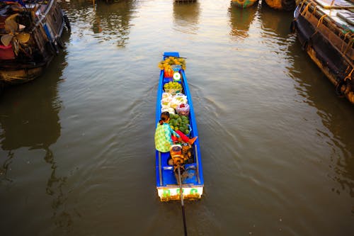 Woman in River Boat Full of Fruits and Vegetables