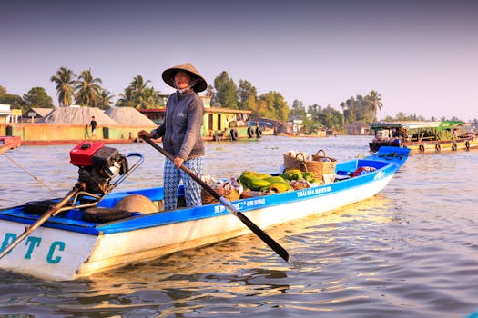 Woman steering a motorized boat filled with goods in vibrant riverine setting.