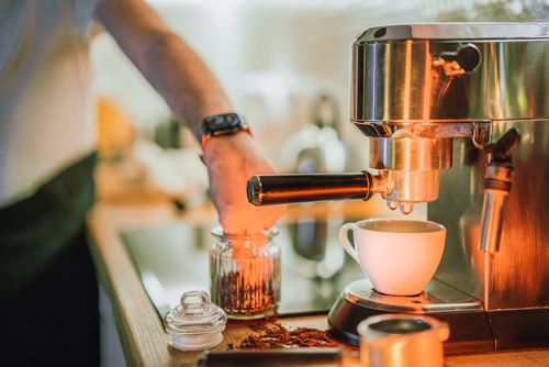 Free Barista using an espresso machine to make coffee, capturing the art of brewing. Stock Photo