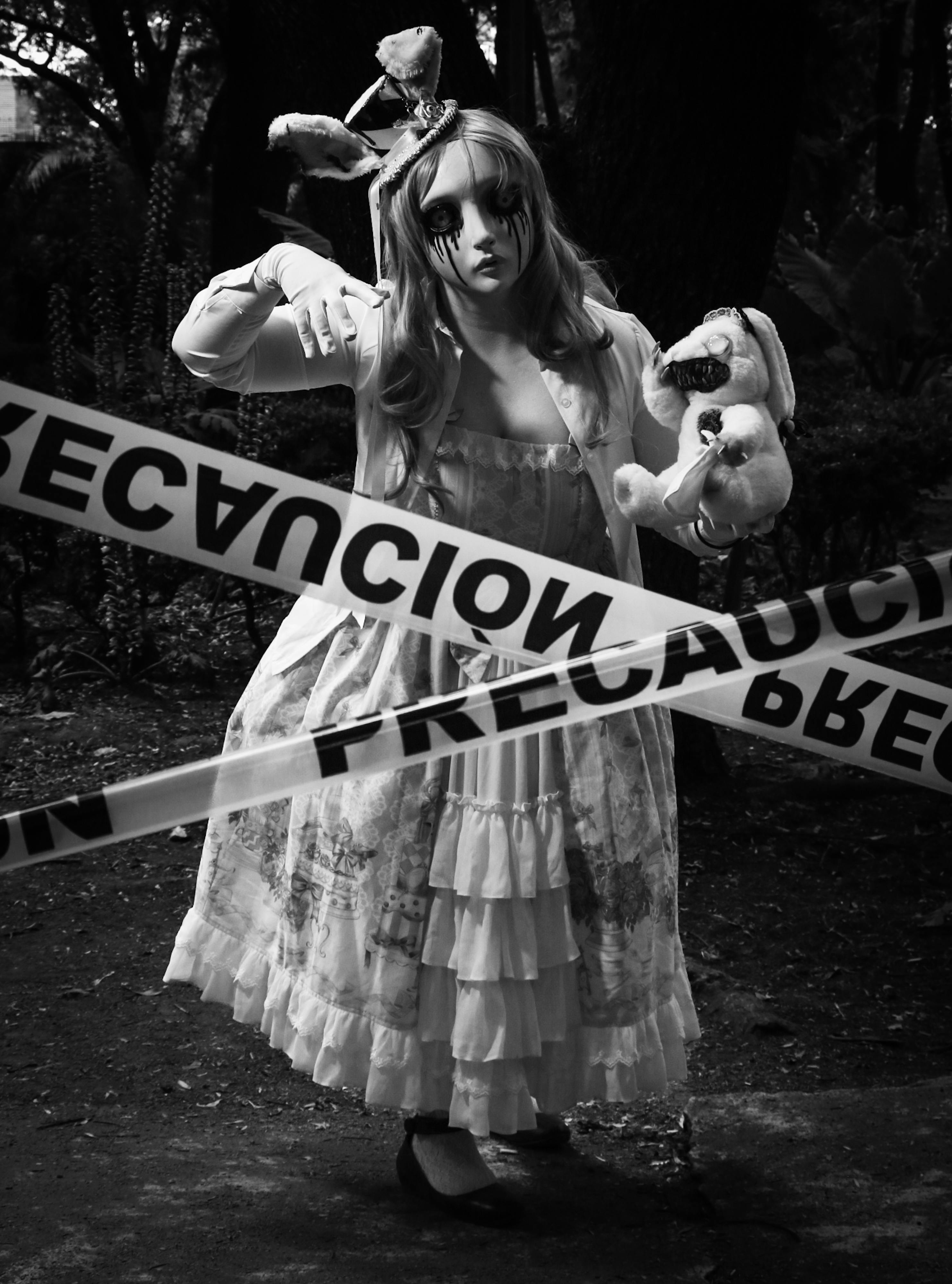 girl wearing halloween costume behind a tape in black and white