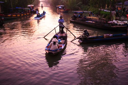Free A lively canal market with boats and merchants at sunrise, creating a serene atmosphere. Stock Photo