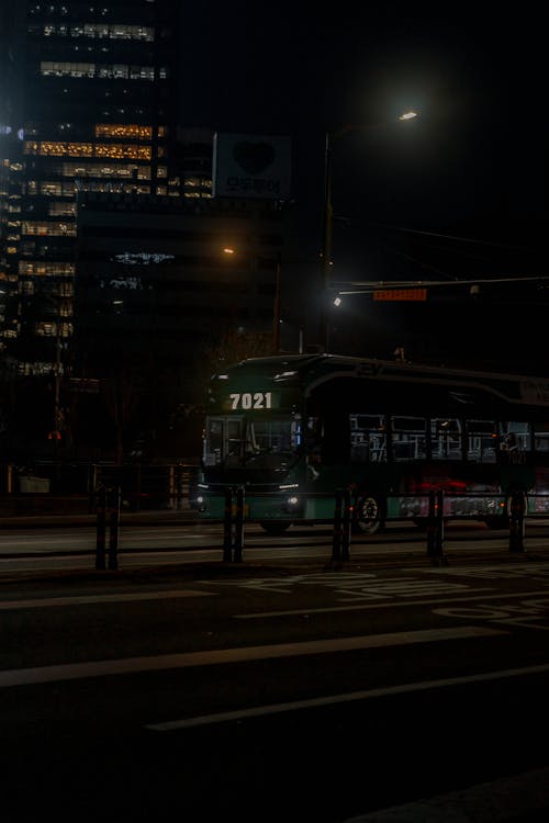 A bus is driving down a street at night