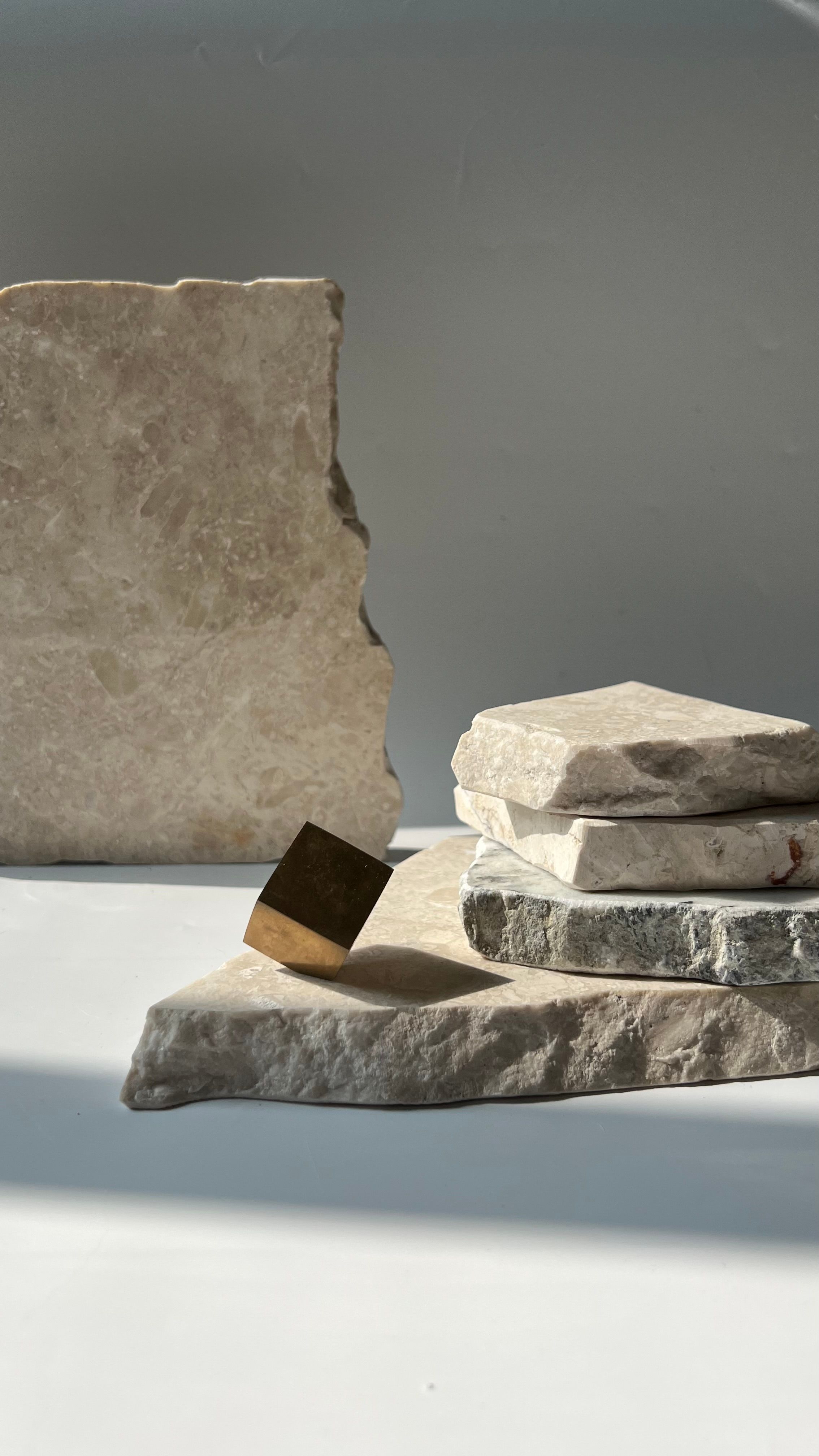 A serene composition of textured stones and sunlight, highlighting natural patterns and materials.