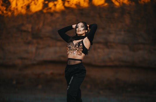 Fashion portrait of a woman in a decorative top posing in a canyon during sunset.