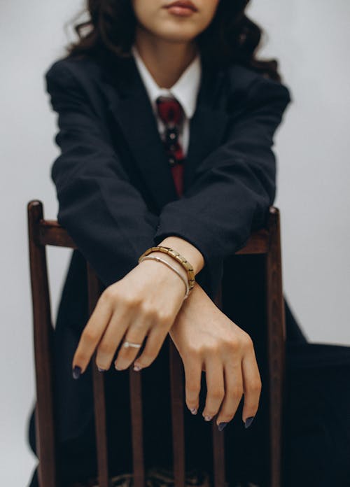 A woman in a suit and tie sitting on a chair