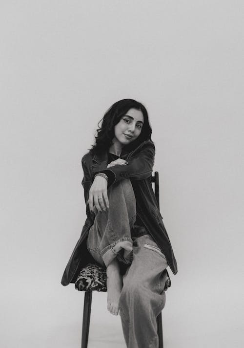 A woman sitting on a chair in black and white